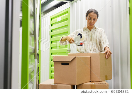 Woman Packing Boxes in Storage Unit 69884881
