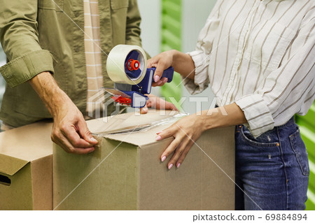 Couple Packing Boxes in Storage Unit Close Up 69884894