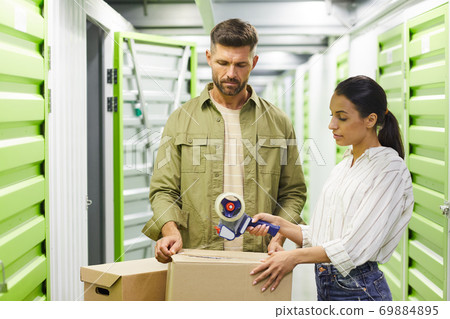 Couple Packing Boxes in Storage Unit 69884895