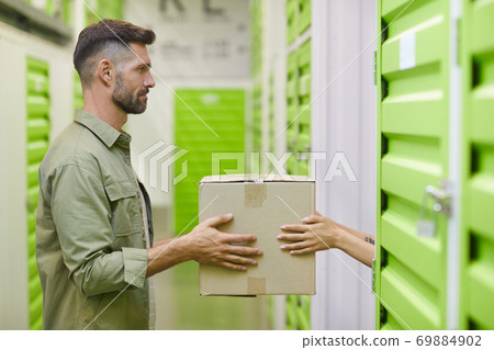 Couple Loading Boxes in Self Storage Unit Couple Loading Boxes in Self Storage Unit 69884902