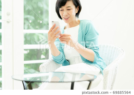 Middle woman making a video call on her smartphone Middle woman making a video call on her smartphone 69885564