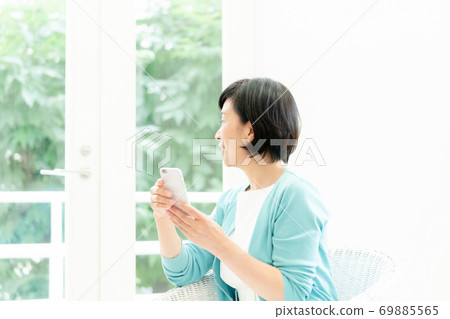 Middle woman making a video call on her smartphone Middle woman making a video call on her smartphone 69885565