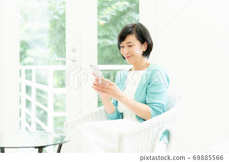 Middle woman making a video call on her smartphone Middle woman making a video call on her smartphone 69885566