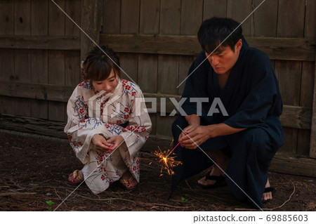 Men and women in yukata with fireworks 69885603