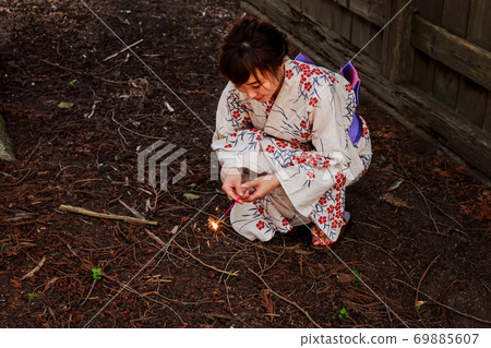 A woman in a yukata with fireworks A woman in a yukata with fireworks 69885607