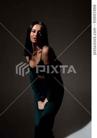 Studio photo of pretty brunette woman in twilight in bra looks into the distance 69885866
