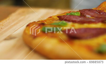 ppetizing hot pepperoni pizza lies on a tray. Close-up. Slow motion ppetizing hot pepperoni pizza lies on a tray. Close-up. Slow motion 69885873