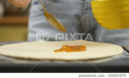 Cooking pizza. The chef prepares the pizza dough. A man or woman is engaged in home business Cooking pizza. The chef prepares the pizza dough. A man or woman is engaged in home business 69885874
