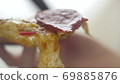 Attractive woman holding slice of pizza and biting it. Hungry girl have a dinner in fast food 69885876