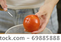 Woman cuts vegetables for salad. Cut tomatoes closeup. The concept of a healthy lifestyle 69885888