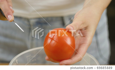 Woman cuts vegetables for salad. Cut tomatoes closeup. The concept of a healthy lifestyle Woman cuts vegetables for salad. Cut tomatoes closeup. The concept of a healthy lifestyle 69885889