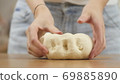 woman on the kitchen table makes domestic food pizza, hands work and pushing stir knead the dough 69885890