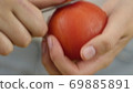 Man or woman peels off a tomato with a knife. Preparation of products for cooking 69885891