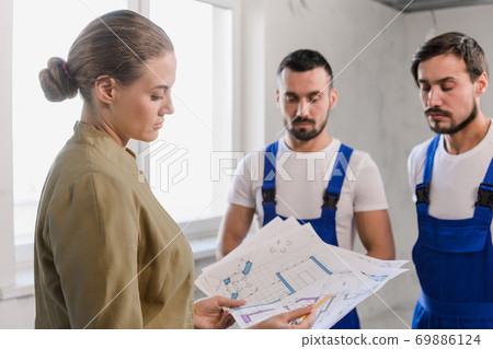 Woman and two builders discussing the layout 69886124