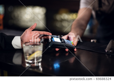 the bartender accepts payment by credit card at the bar 69886324
