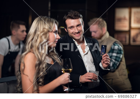 a man and a woman come to a nightclub and drink cocktails a man and a woman come to a nightclub and drink cocktails 69886327
