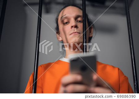 A dangerous criminal with tattoos on his face in prison got a smartphone to commit cyber crimes over the Internet. 69886390