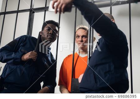 Theme party on the theme of prison. The guys take a fun selfie with each other on their smartphone. 69886395