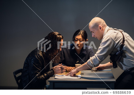A police officer familiarizes the suspect with the documents in his case A police officer familiarizes the suspect with the documents in his case 69886639