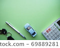 微型汽車，鑰匙和文具在綠色繪圖紙上排列（水平上邊距） 69889281