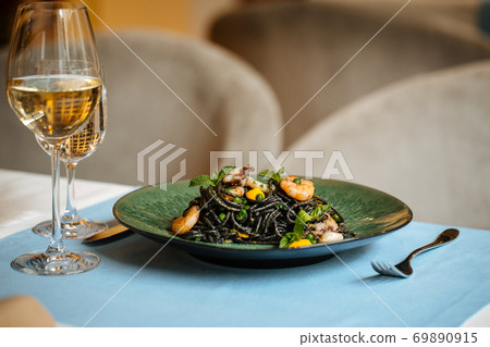 Black spaghetti with seafood and saffron sauce Black spaghetti with seafood and saffron sauce 69890915
