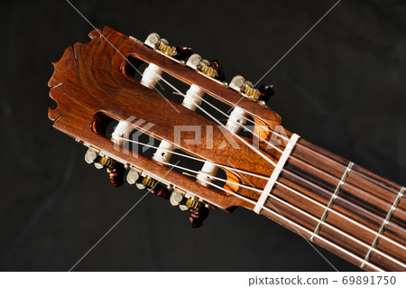Closeup of acoustic guitar frets, fretboard, tuners, headstock and truss rod Closeup of acoustic guitar frets, fretboard, tuners, headstock and truss rod 69891750