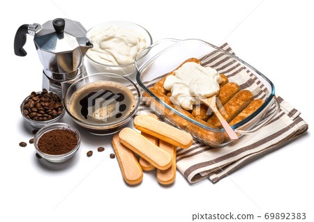 tiramisu dessert cooking - Traditional Italian Savoiardi ladyfingers Biscuits and cream in glass baking dish isolated on white with clipping path 69892383