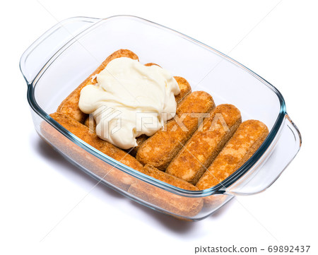 tiramisu dessert cooking - Traditional Italian Savoiardi ladyfingers Biscuits and cream in glass baking dish isolated on white with clipping path 69892437