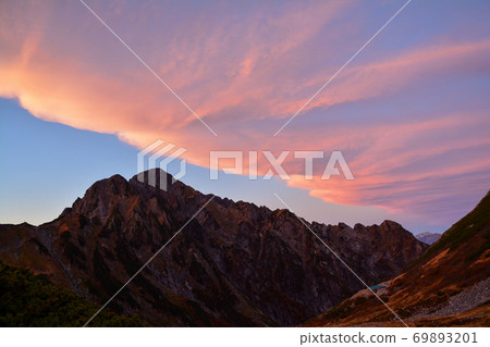 在Mudake山的茜色的雲彩在黃昏的北阿爾卑斯。立山黑部阿爾卑斯山脈路線。肯達克山 69893201