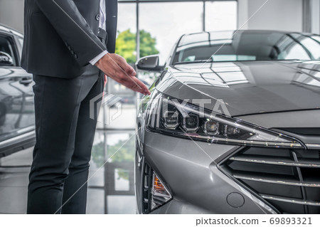 Close up of a male in black suit showing the car headlight 69893321