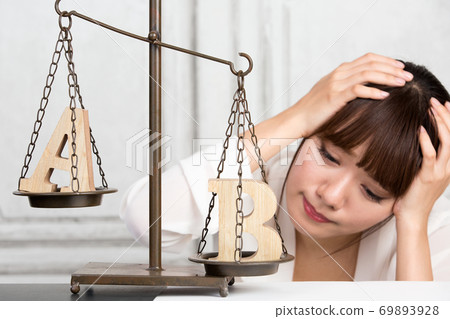 Woman comparing A and B Woman comparing A and B 69893928