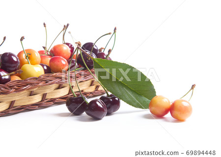 Yellow and red sweet cherry in basket with green leaf isolate on white. Yellow and red sweet cherry in basket with green leaf isolate on white. 69894448