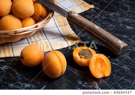 Fresh organic apricots in basket. Group of harvested apricots in basket with vintage knife.. Fresh organic apricots in basket. Group of harvested apricots in basket with vintage knife.. 69894547