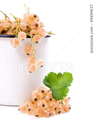 White cup with white currant berry in it and small bunch of white currant with green leaf isolated on white.. White cup with white currant berry in it and small bunch of white currant with green leaf isolated on white.. 69894637