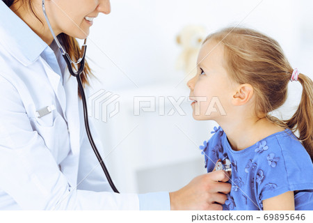 Doctor examining a little girl by stethoscope. Happy smiling child patient at usual medical inspection. Medicine and healthcare concepts Doctor examining a little girl by stethoscope. Happy smiling child patient at usual medical inspection. Medicine and healthcare concepts 69895646
