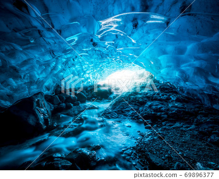Entrance of an crystal blue ice cave with underground river inside Vatnajokull glacier, Iceland 69896377