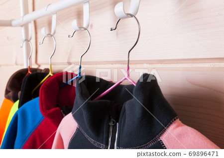 Colorful fleece jackets are on a rack, close-up photo 69896471