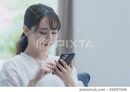 A woman using a smartphone A woman using a smartphone 69897046