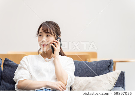 A woman talking on a smartphone A woman talking on a smartphone 69897056