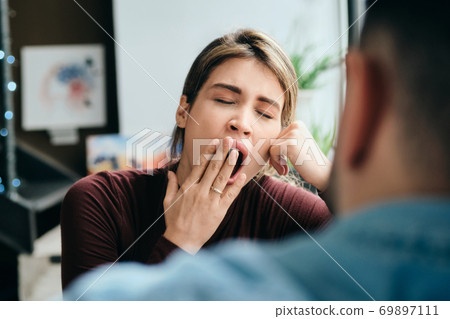 Woman Yawning During Boring Conversation With Partner Woman Yawning During Boring Conversation With Partner 69897111