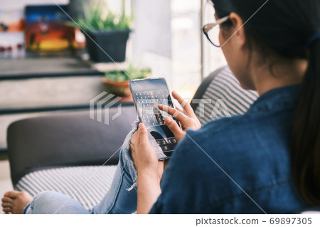 Young Woman Playing Sudoku Game With App On Phone 69897305
