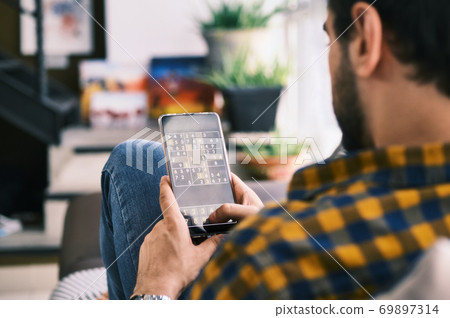 Young Man Playing Sudoku Game With App On Smartphone Young Man Playing Sudoku Game With App On Smartphone 69897314
