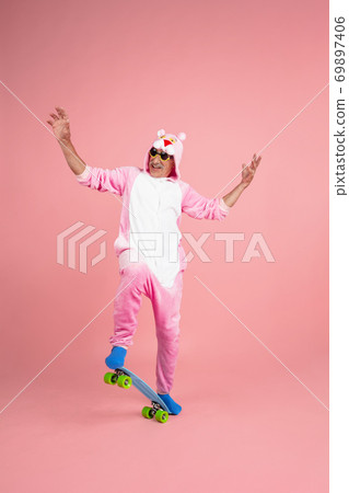 Senior hipster man in stylish pink attire isolated on pink background. Tech and joyful elderly lifestyle concept Senior hipster man in stylish pink attire isolated on pink background. Tech and joyful elderly lifestyle concept 69897406