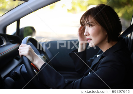 A woman who feels a headache while driving 69897645