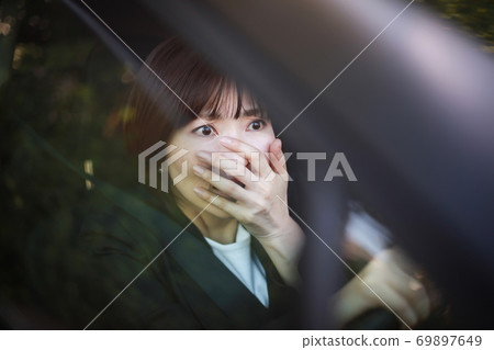 A woman with a surprised expression while driving 69897649