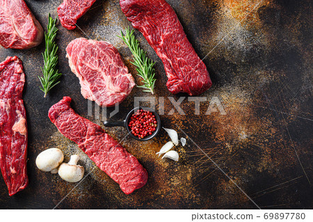 Variety, of raw beef steaks flap flank Steak, machete steak or skirt cut, Top blade or flat iron beef and tri tip, triangle roast with denver cut top view over old rustic metal surface space for text 69897780