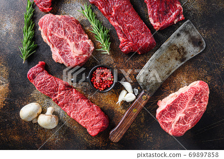 Set of different alternative types of raw beef steaks,with butcher cleaver knife on a rustic metall background top view layflat Set of different alternative types of raw beef steaks,with butcher cleaver knife on a rustic metall background top view layflat 69897858