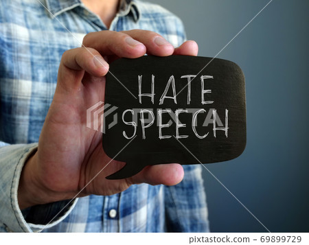 Hate speech concept. A hand holds a black plate. Hate speech concept. A hand holds a black plate. 69899729