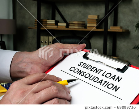 Man fills out the form for student loan consolidation. Man fills out the form for student loan consolidation. 69899730