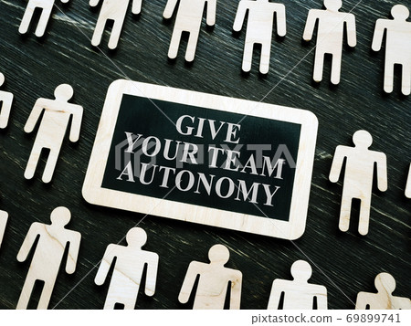 Giving your team autonomy quote and wooden figures. 69899741